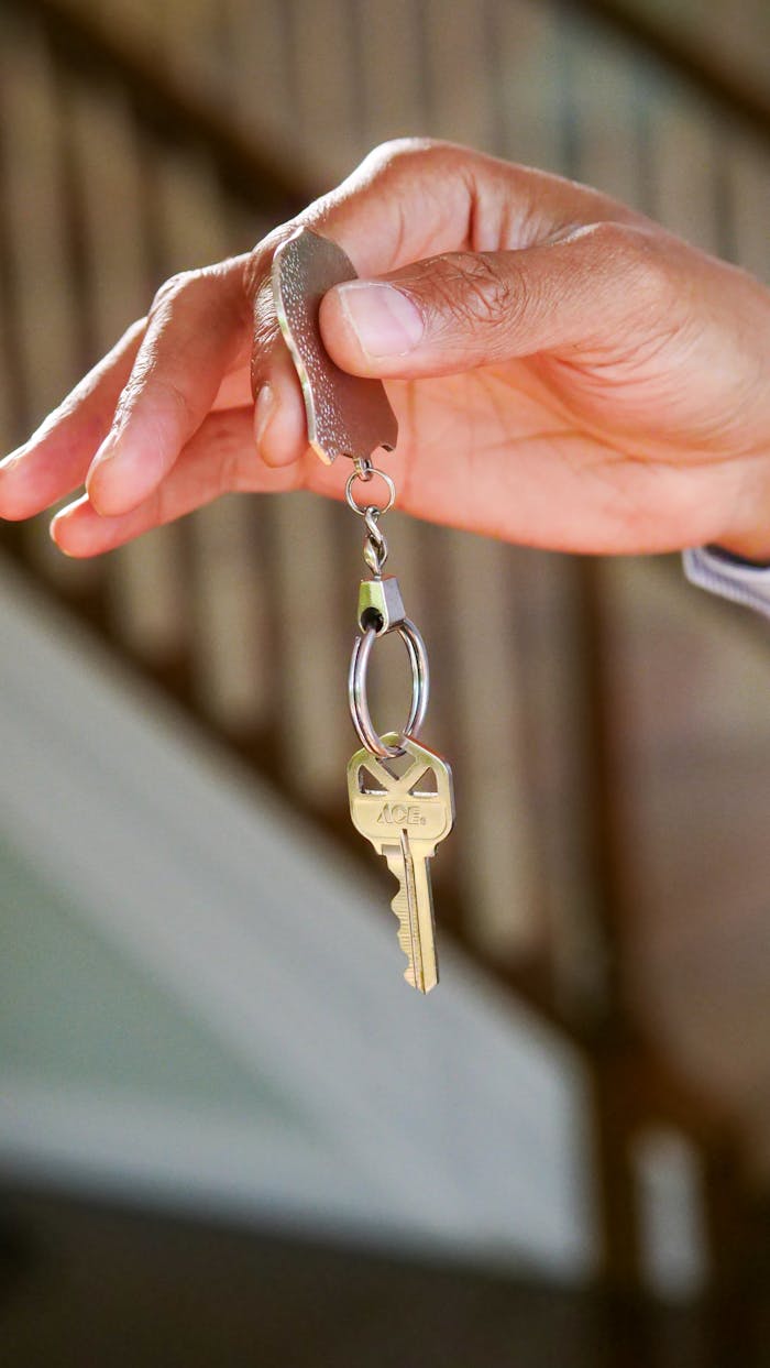 ours-journey Close-up of a hand holding a key, symbolizing new homeownership or rental.